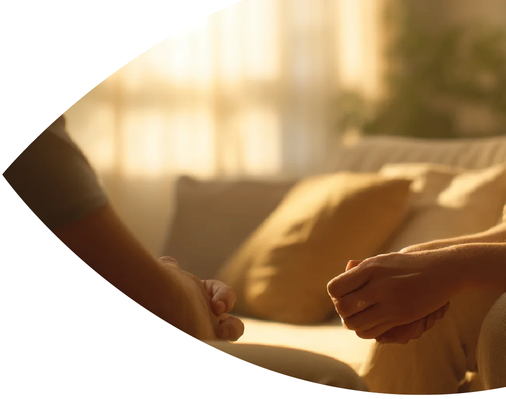 Zwei Personen sitzen sich im warmen Licht gegenüber.